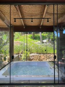 uma grande banheira num quarto com uma janela em Portogalo suíte com SPA em Angra dos Reis
