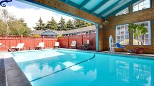 a swimming pool with chairs and a house at Best Western Country Inn in Fortuna