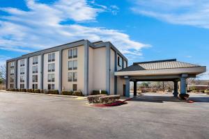 un gran edificio blanco con aparcamiento en Quality Inn & Suites North Little Rock en North Little Rock