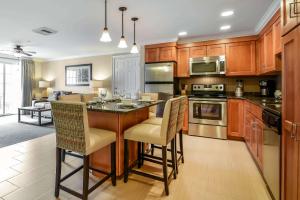 a kitchen with wooden cabinets and a kitchen island with chairs at South Mountain Resort in Lincoln