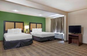 a hotel room with two beds and a flat screen tv at Extended Stay America Select Suites - Charlotte - Tyvola Rd - Executive Park in Charlotte