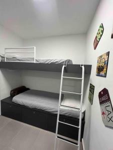 ein Zimmer mit zwei Etagenbetten und einer Leiter in der Unterkunft Studio America Gardens in Rio de Janeiro