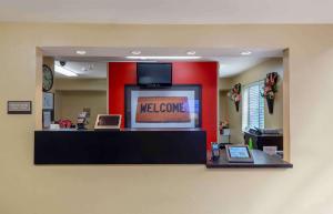 ローリーにあるExtended Stay America Suites - Raleigh - North Raleigh - Wake Towne Drのロビーのフロントカウンターにウェルカムサインを用意しています。