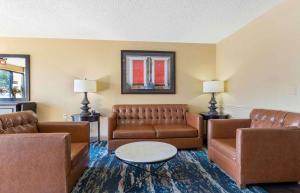 a living room with brown leather couches and a table at Extended Stay America Suites - Tulsa - Midtown in Tulsa