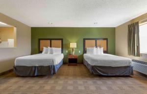 duas camas num quarto com paredes verdes em Extended Stay America Suites - Tulsa - Midtown em Tulsa