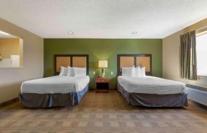two beds in a room with green walls at Extended Stay America Suites - Tulsa - Midtown in Tulsa