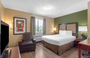 a hotel room with a bed and a chair at Extended Stay America Select Suites - Memphis - Cordova in Memphis