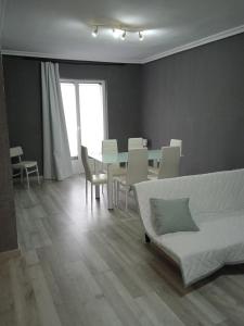 sala de estar con sofá, mesa y sillas en Apartamento Roma, en Ciudad Rodrigo