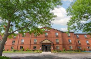 a large red brick building with a tree at Extended Stay America Suites - Toledo - Maumee in Maumee