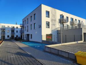 an apartment building with a swimming pool in front of it at STARCO Apartamenty Centrum in Stargard