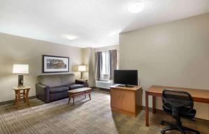 a living room with a couch and a desk with a television at Extended Stay America Suites - Cleveland - Great Northern Mall in North Olmsted