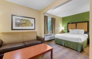 a hotel room with a bed and a couch at Extended Stay America Suites - Toledo - Maumee in Maumee