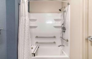 een badkamer met een wit bad en een douche bij Extended Stay America Premier Suites - Fort Lauderdale - Deerfield Beach in Deerfield Beach