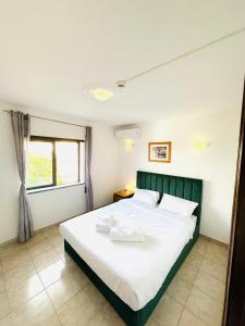 - une chambre avec un lit doté de draps blancs et une fenêtre dans l'établissement Portimao Central Holiday Guesthouse, à Portimão