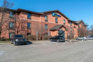 a large brick building with cars parked in a parking lot at Extended Stay America Select Suites - Detroit - Warren in Warren