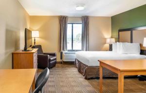 沃倫的住宿－Extended Stay America Select Suites - Detroit - Warren，配有一张床和一张书桌的酒店客房