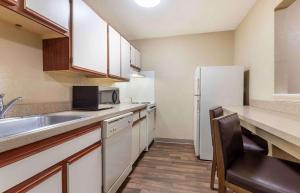 una pequeña cocina con fregadero y nevera. en Extended Stay America Select Suites - Detroit - Warren, en Warren