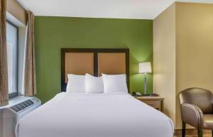 Cama en habitación con pared verde en Extended Stay America Select Suites - Detroit - Ann Arbor - University South, en Ann Arbor
