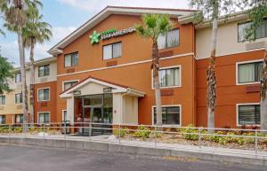 un hôtel avec des palmiers devant un bâtiment dans l'établissement Extended Stay America Select Suites Tampa Airport Memorial Hwy, à Tampa