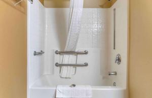 a bathroom with a tub and a shower with towels at Extended Stay America Select Suites - Detroit - Ann Arbor - University South in Ann Arbor