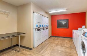 a laundry room with white washes and a red wall at Extended Stay America Select Suites - Richmond - Innsbrook in Richmond