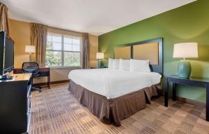 a hotel room with a bed and a desk at Extended Stay America Suites - Raleigh - RTP - 4919 Miami Blvd in Durham +75 photos