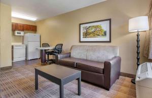 Extended Stay America Suites - Raleigh - RTP - 4919 Miami Blvd في دورهام: غرفة معيشة مع أريكة وطاولة