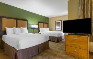 a hotel room with two beds and a flat screen tv at Extended Stay America Select Suites - Atlanta - Buckhead in Atlanta