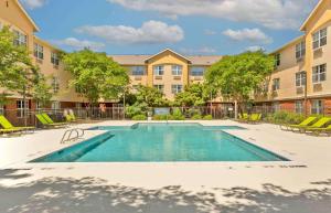 una imagen de una piscina en un complejo de apartamentos en Extended Stay America Suites - Raleigh - RTP - 4919 Miami Blvd en Durham