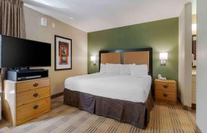 a bedroom with a bed and a flat screen tv at Extended Stay America Select Suites - Atlanta - Marietta - Wildwood in Atlanta