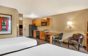 a hotel room with a bed and a desk and a kitchen at Extended Stay America Suites - Bakersfield - Chester Lane in Bakersfield