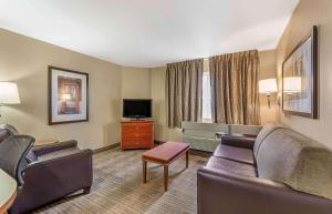 Extended Stay America Suites - Bakersfield - Chester Lane في بيكرسفيلد: غرفة في الفندق مع أريكة وتلفزيون