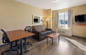 uma sala de estar com um sofá, uma cadeira e uma mesa em Extended Stay America Suites - Anchorage - Midtown em Anchorage