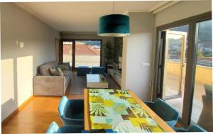 a living room with a table and blue chairs at Apartamento Exclusivo Bueu Centro, 50M playa in Bueu