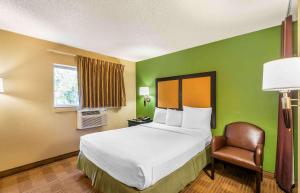 um quarto de hotel com uma cama e uma cadeira em Extended Stay America Suites - Destin - US 98 - Emerald Coast Pkwy em Destin