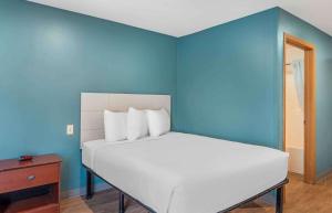 1 dormitorio con 1 cama con pared azul en Extended Stay America Select Suites - Little Rock - Southwest, en Little Rock