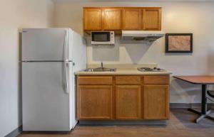 a kitchen with a white refrigerator and a sink at Extended Stay America Select Suites - Orlando - Sanford - Airport in Sanford