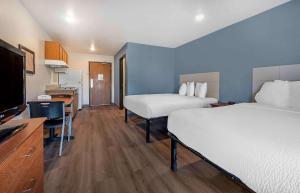 Extended Stay America Select Suites - Orlando - Sanford - Airport في سانفورد: غرفة فندقية بسريرين وتلفزيون بشاشة مسطحة