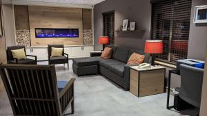 uma sala de estar com um sofá e duas cadeiras em Country Inn & Suites by Radisson, Covington, LA em Covington