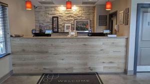 a lobby with a reception desk with a welcome counter at Country Inn & Suites by Radisson, Covington, LA in Covington