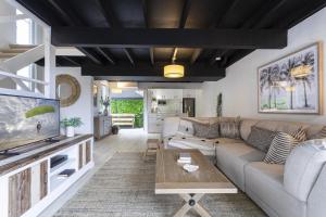 a living room with a couch and a table at Beachside 2-Bed House with Pool, Courtyard & BBQ in Sunshine Beach
