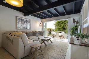 a living room with a couch and a table at Beachside 2-Bed House with Pool, Courtyard & BBQ in Sunshine Beach
