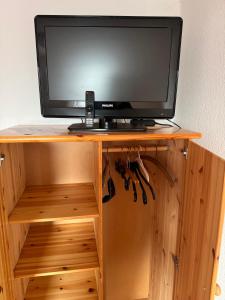 a television sitting on top of a wooden stand at Pension FAULPELZ - Doppelzimmer Standard in Niederorschel