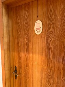 a wooden door with a clock on it at Pension FAULPELZ - Doppelzimmer Standard in Niederorschel