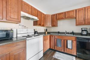 una cocina con armarios de madera y electrodomésticos blancos en Mesmerizing Apartment In Normal, IL Bloomington, IL, en Normal