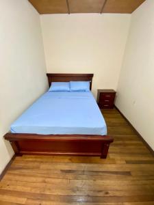 a bed in a small room with a wooden floor at Airbnb_espinoza in Cuenca