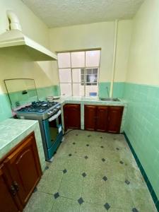 an empty kitchen with a stove and a window at Airbnb_espinoza in Cuenca
