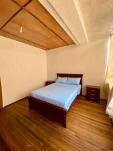 a bedroom with a bed with a wooden floor at Airbnb_espinoza in Cuenca