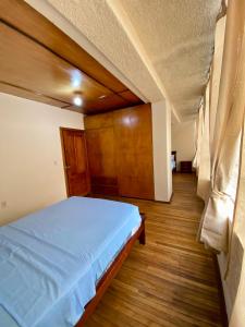 a bedroom with a bed and a wooden floor at Airbnb_espinoza in Cuenca