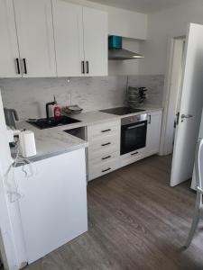 a kitchen with white cabinets and a stove top oven at Cozy Private Room Close Central Ideal Location in London
